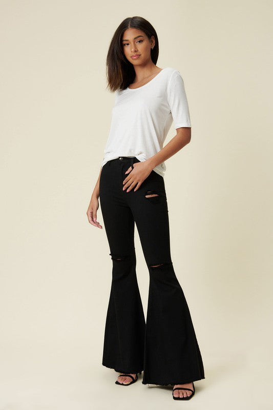 RARA Boutique high rise distressed ultra flare bell bottom jeans in vibrant denim with frayed details and wide leg silhouette.