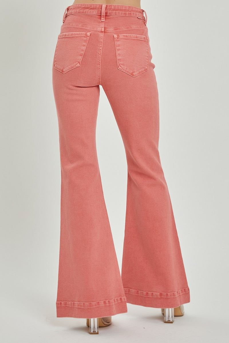 Risen high rise patch pocket bell bottom jeans with distressed details and flared legs, displayed on a hanger.