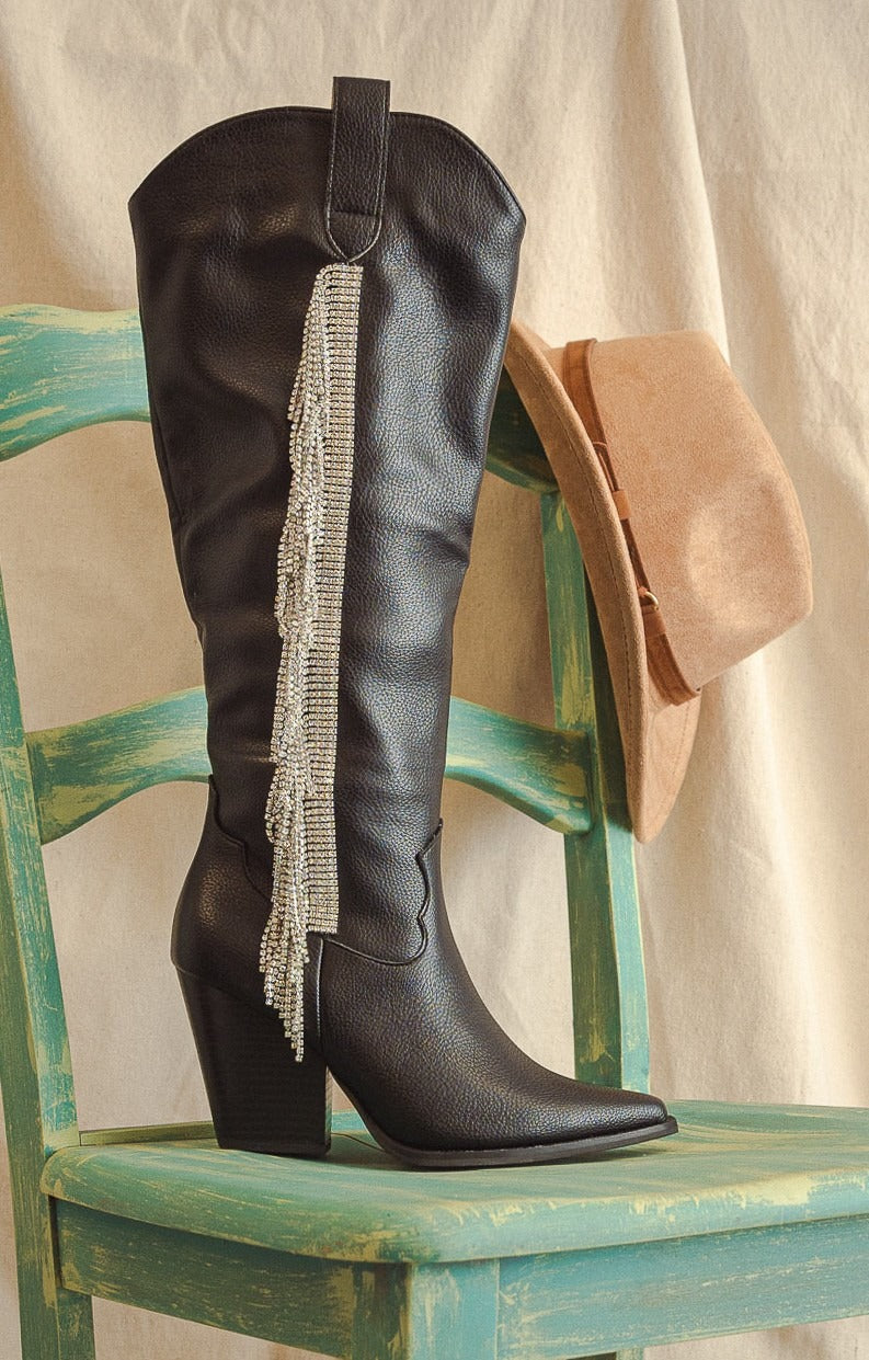 Rara Boutique rhinestone fringe knee-high western boots with decorative embellishments and intricate stitching.
