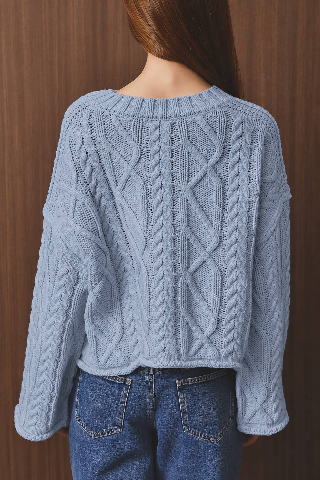 LE LIS oversized cropped cable knit sweater featuring chunky knit texture and relaxed fit, displayed on a hanger.