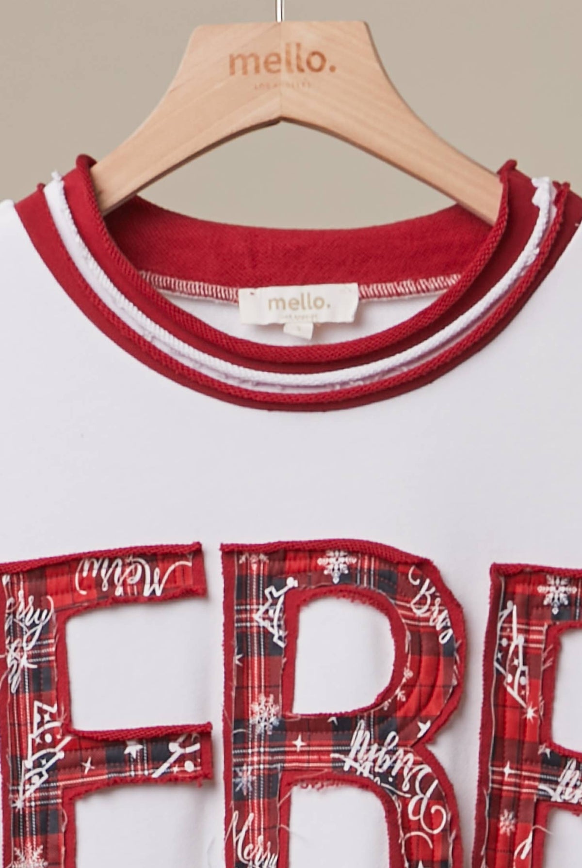 Mello Tuesday holiday Christmas letter sweatshirt featuring festive red and white design with holiday-themed lettering.