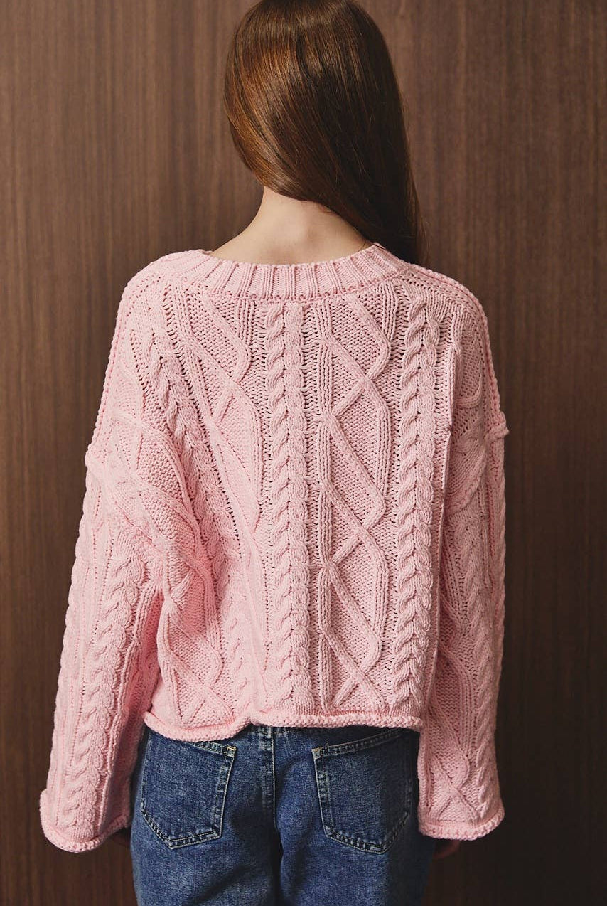 LE LIS oversized cropped cable knit sweater in cozy textured fabric, featuring a relaxed fit and chunky knit pattern.