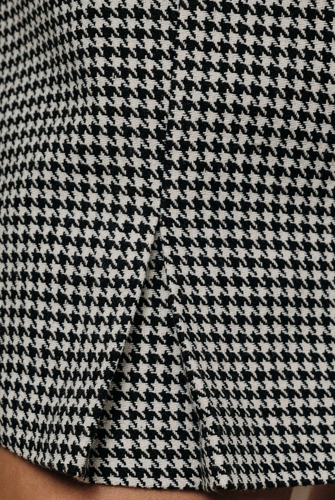Sunday Edition by LE LIS houndstooth mini skort with front pockets, styled on a model for a trendy, casual look.