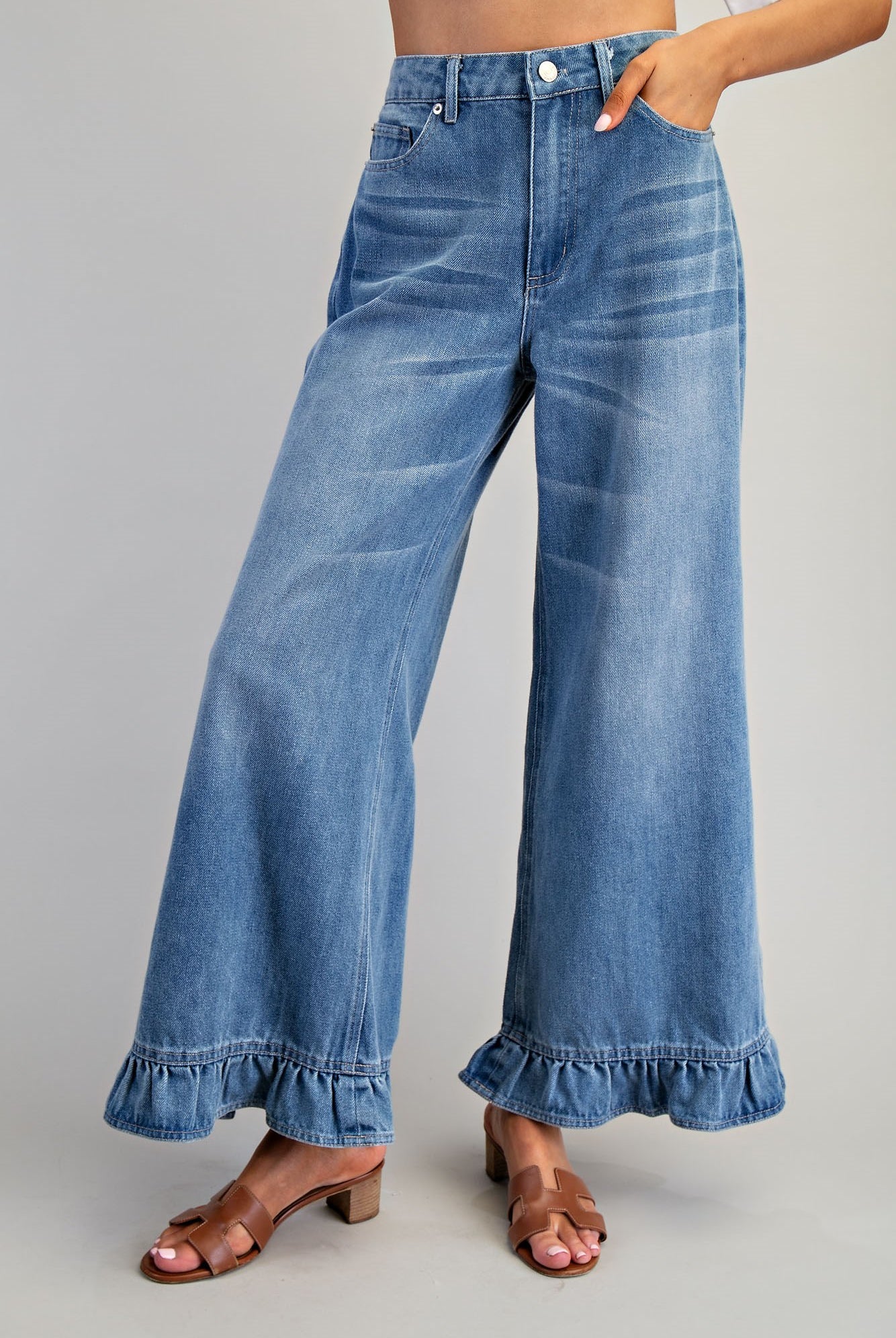 Ruffle hem wide-leg mineral washed jeans from RARA Boutique featuring relaxed fit and stylish ruffle detailing at the hem.