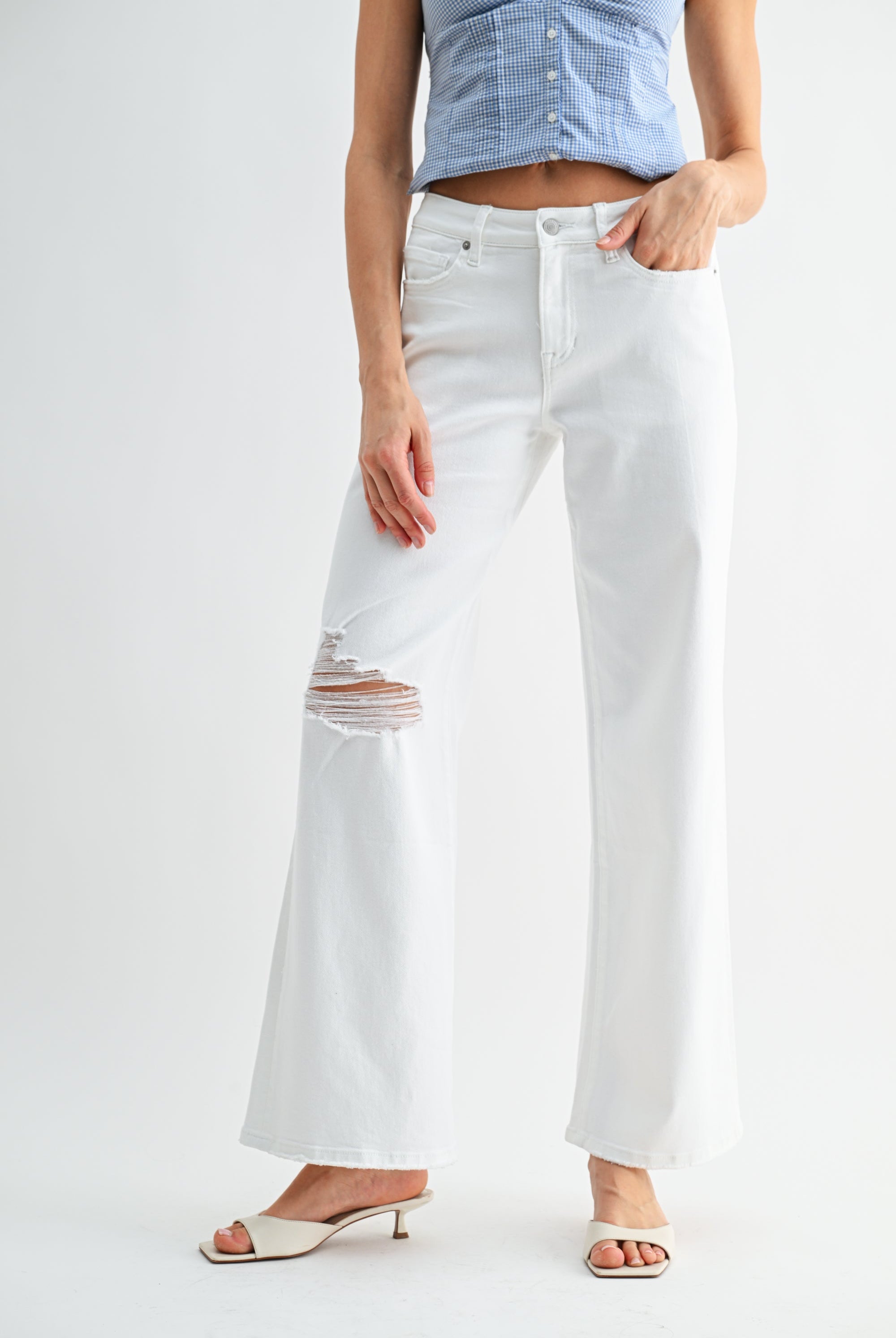 Light wash mid-rise distressed wide-leg jeans from RARA Boutique with ripped details and relaxed fit.