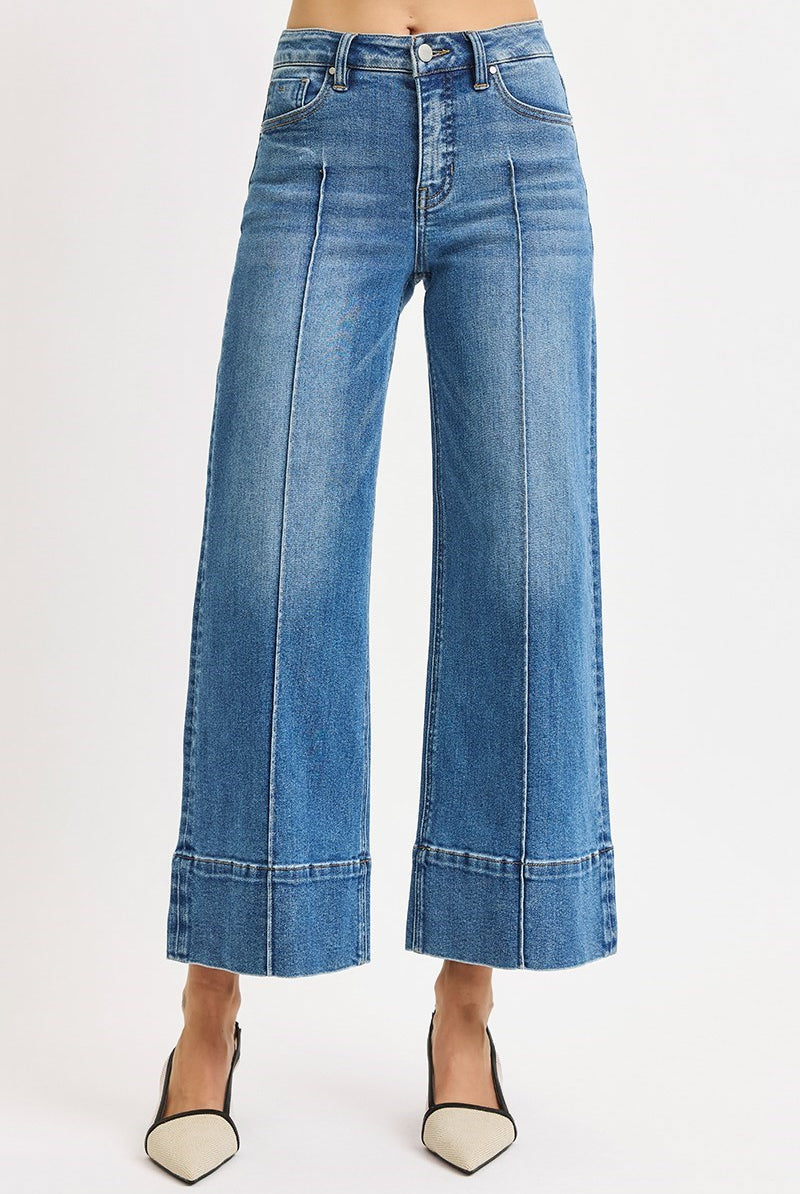 Medium wash Risen pintuck tummy control wide leg cropped jeans with wide hem, showcasing stylish fit and relaxed silhouette.
