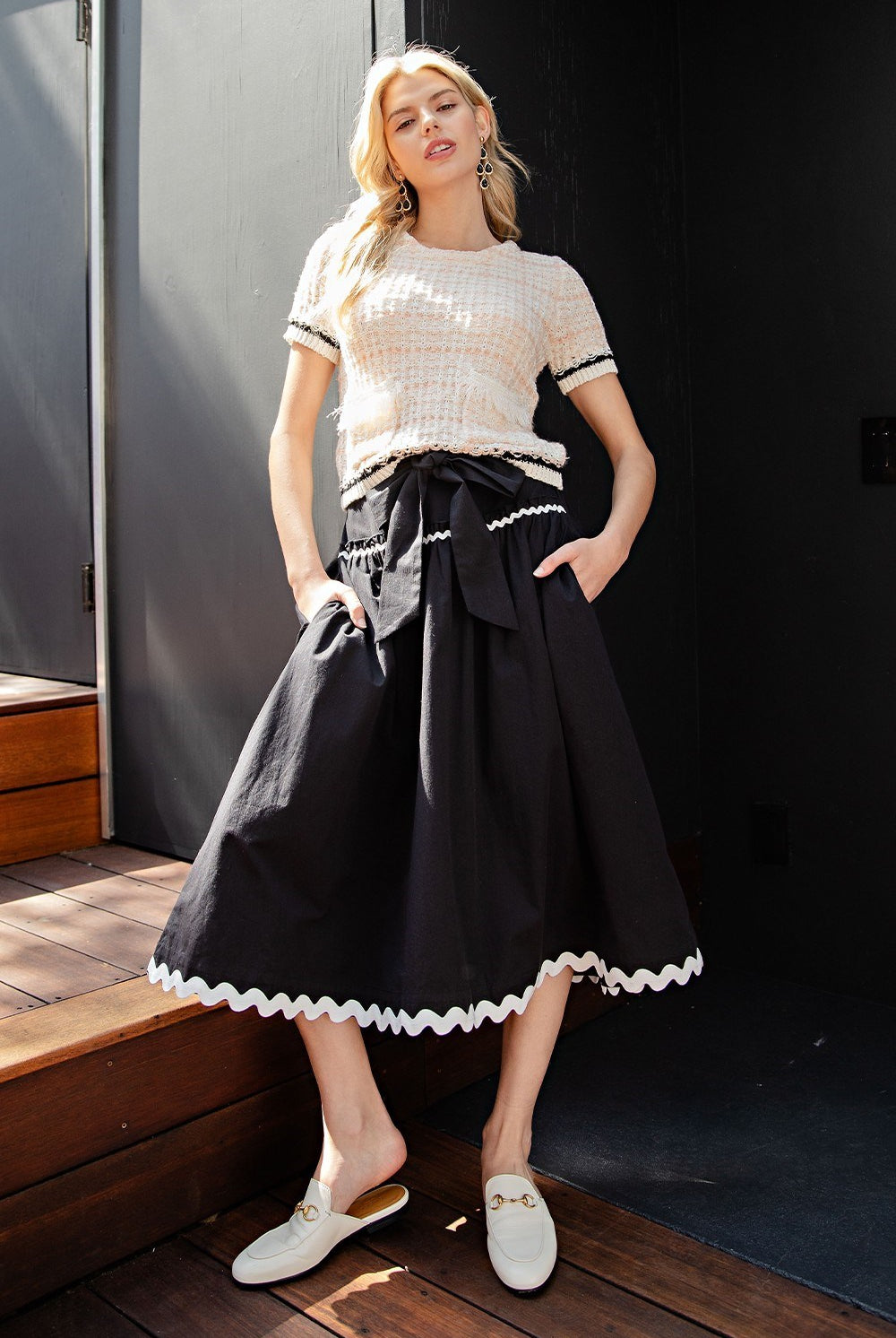 RARA Boutique bow front ric rac trim A-line midi skirt, stylish and feminine, shown in a light fabric with decorative trim.