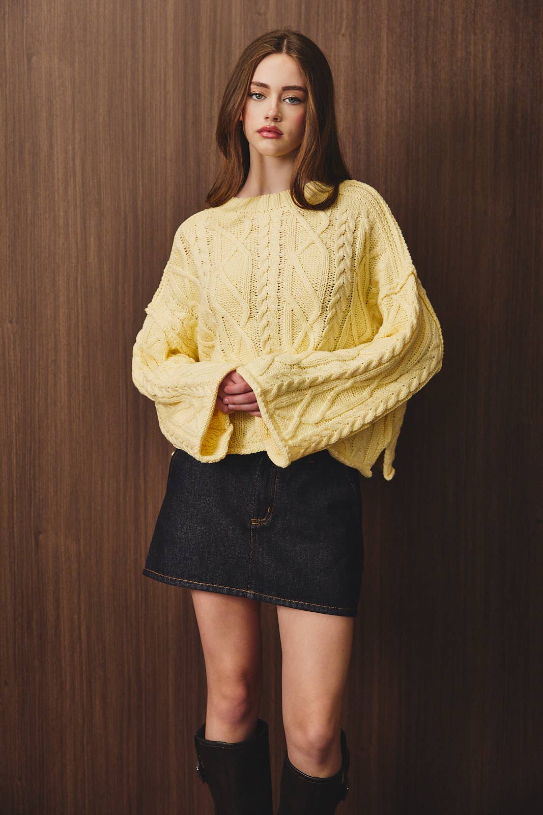 LE LIS oversized cropped cable knit sweater in soft, chunky knit fabric, showing the textured cable pattern and relaxed fit.