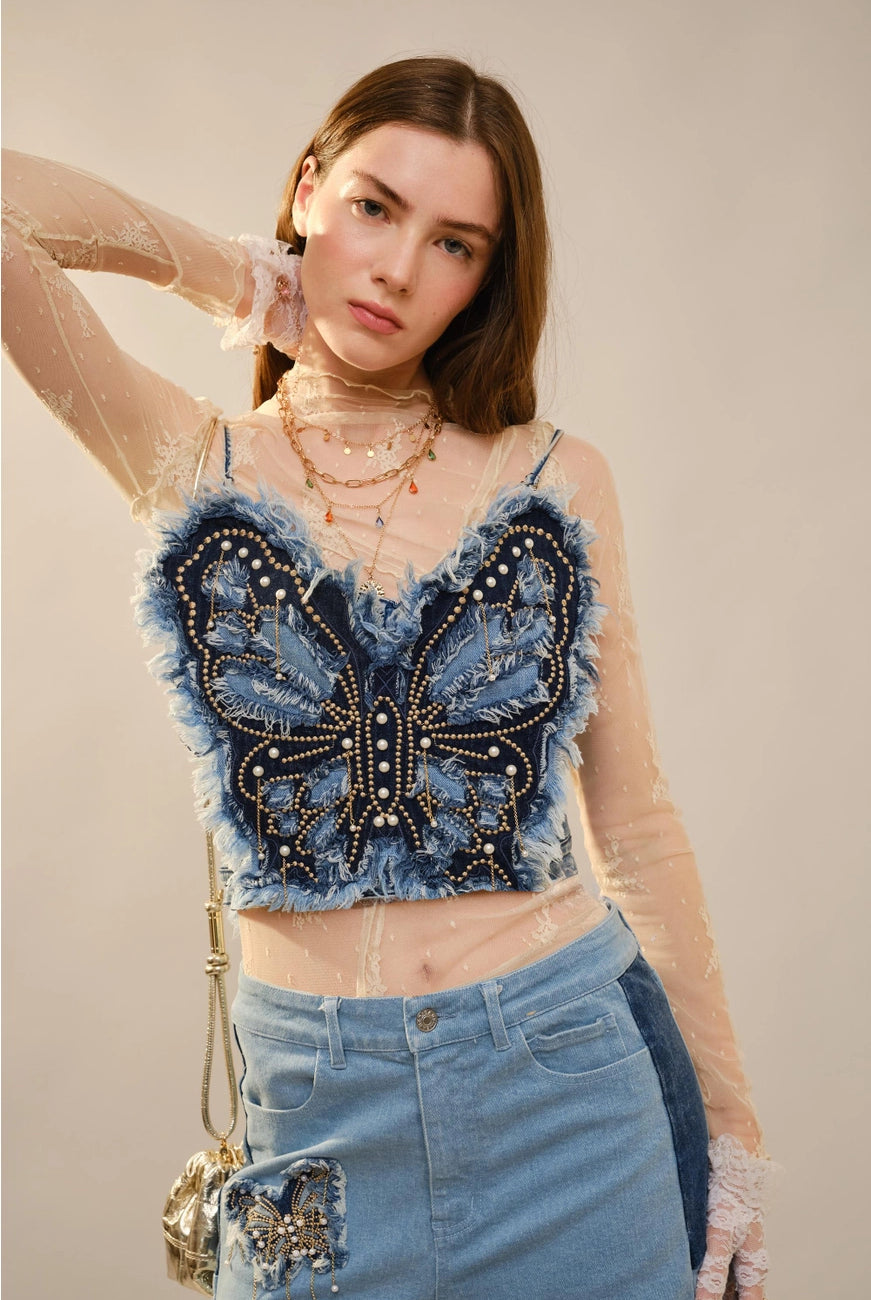 Blue RARA Boutique denim corset top with butterfly embellishments, styled as a fashionable blouse with intricate details.