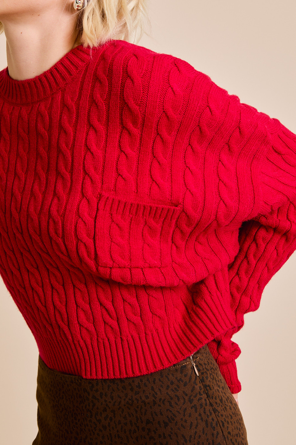 Red RARA Boutique Dolman sleeve cable knit cropped sweater with a front pocket, detailed close-up of the textured knit fabric.