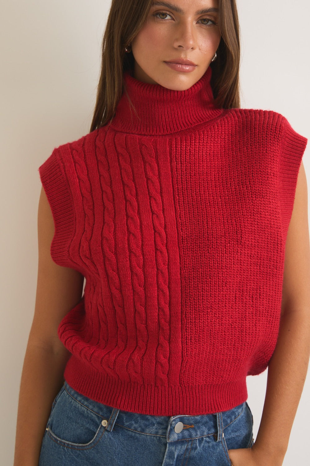 Red ribbed and cable knit turtleneck sweater vest by RARA Boutique, featuring a cozy, textured design perfect for layering.