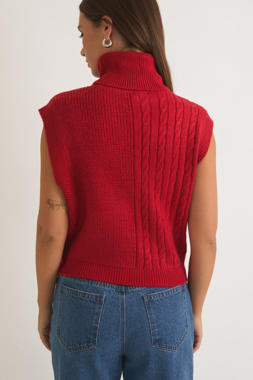 Red ribbed and cable knit turtleneck sweater vest by RARA Boutique, featuring a cozy layered look and textured knit pattern.