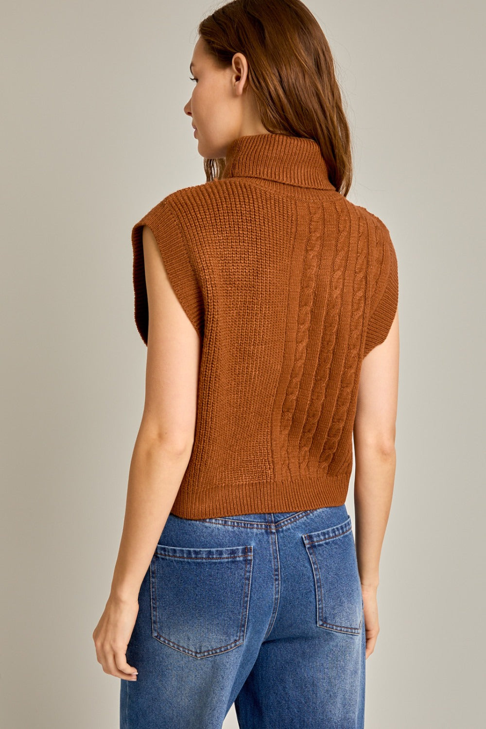 Caramel ribbed and cable knit turtleneck sweater vest by RARA Boutique, featuring a cozy sleeveless design and textured knit pattern.