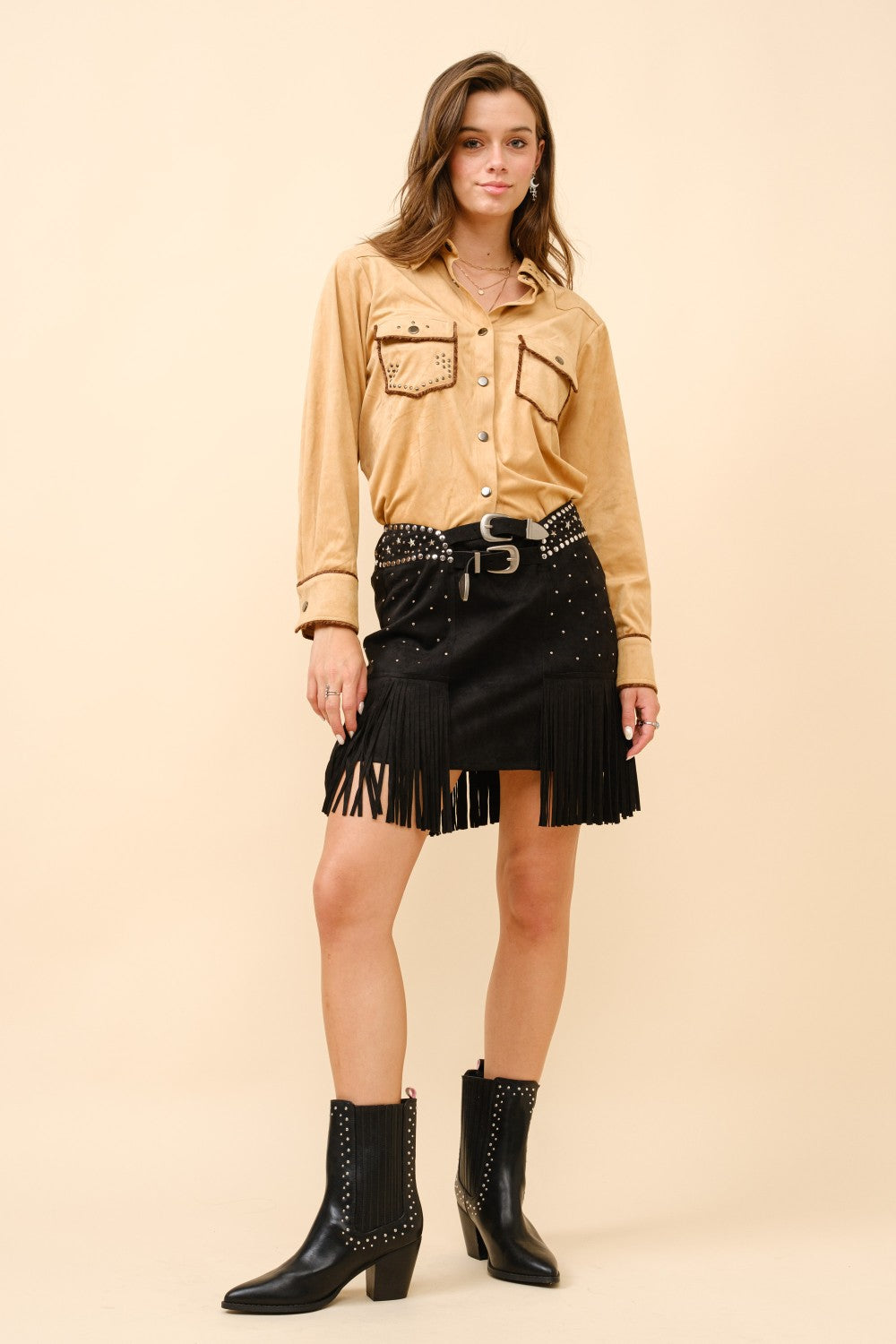 Black double belted star studded suede fringe mini skirt by RARA Boutique, showing details of the star accents and fringe trim.