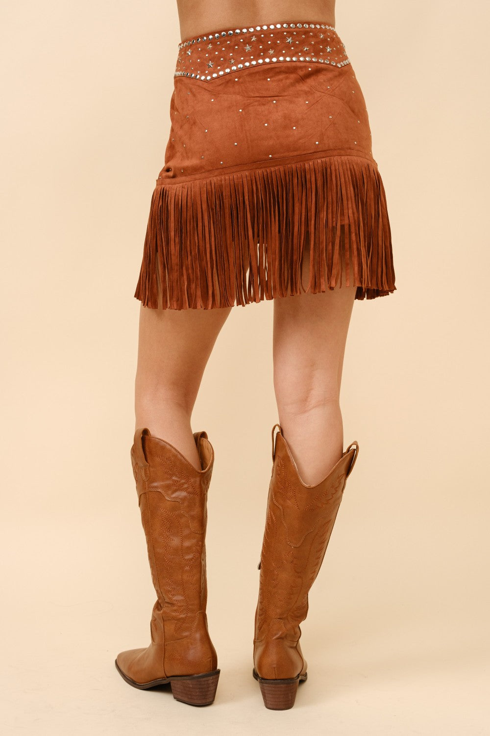 Blue suede mini skirt with double belts, star studs, and fringe detailing from RARA Boutique.