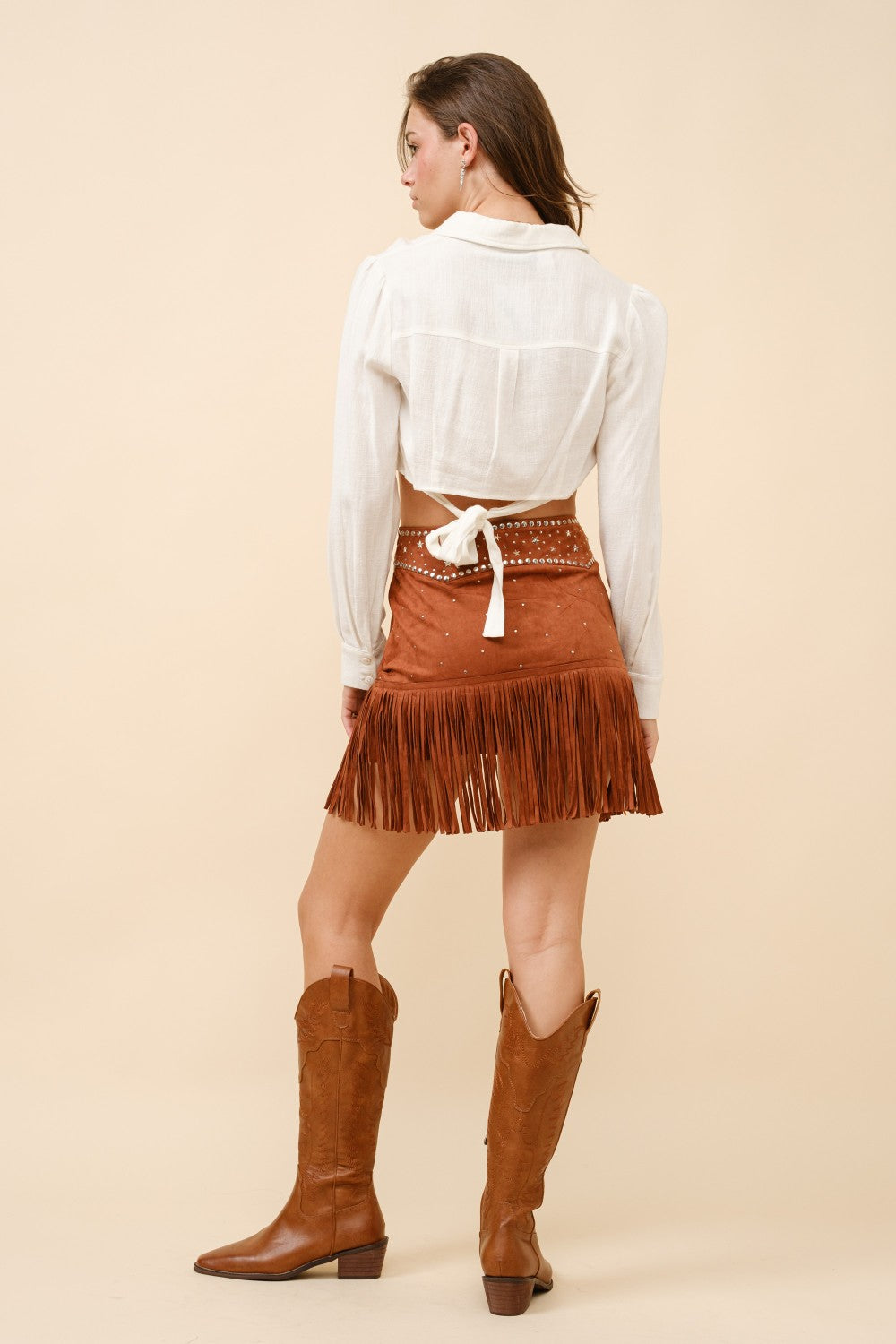 Blue suede mini skirt with double belts, star studs, and fringe detail from RARA Boutique, featuring a stylish and edgy design.