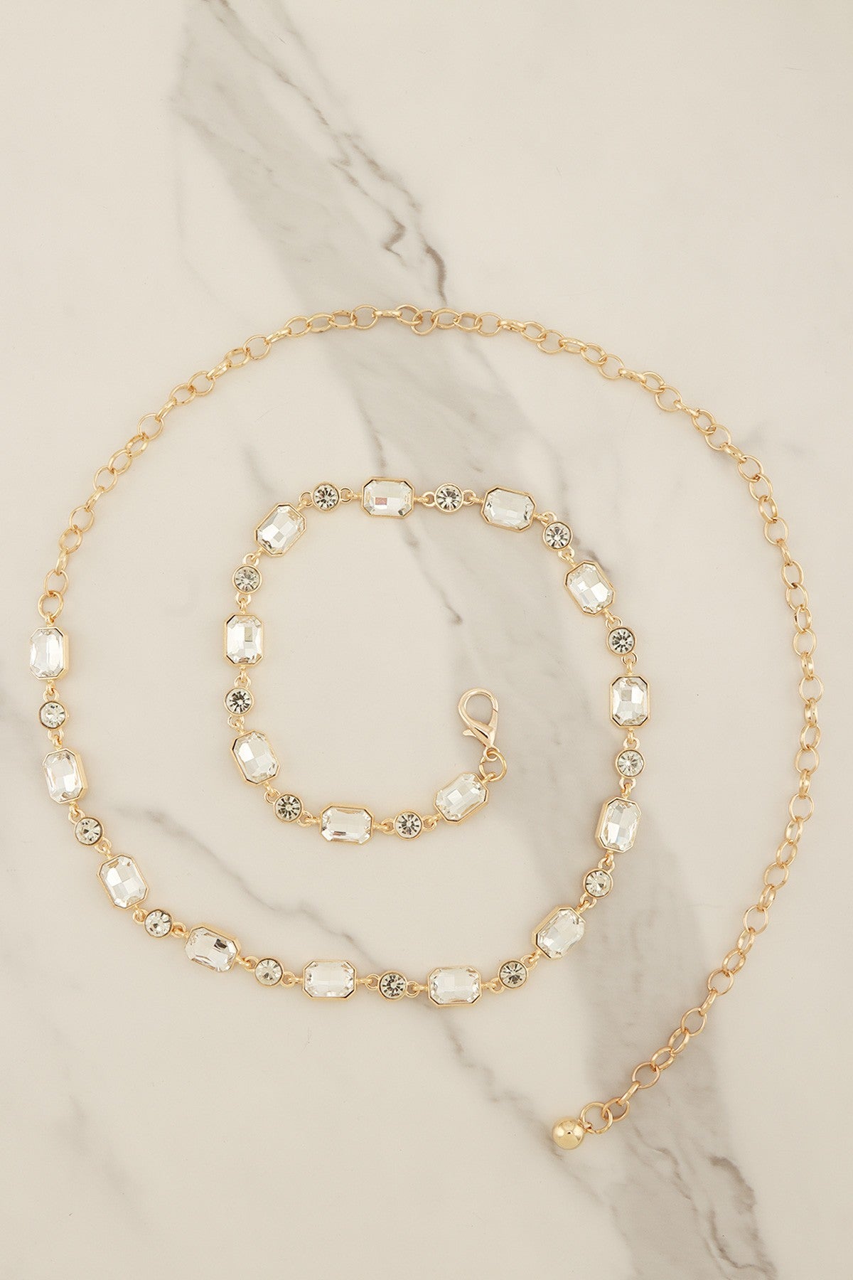 Emerald-cut crystal chain belt by RARA Boutique featuring sparkling crystals and a sleek metal design for elegant style.