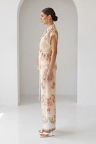 Watercolor floral baroque border wide-leg pants by RARA Boutique in peach with flowing fabric and intricate floral patterns.