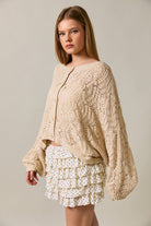 Long sleeve crochet cardigan by LE LIS featuring intricate knit pattern, worn open over a casual outfit.