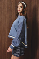 Le Lis sweatshirt featuring knit sweater sleeves, soft fabric, and stylish design, shown in a close-up image.