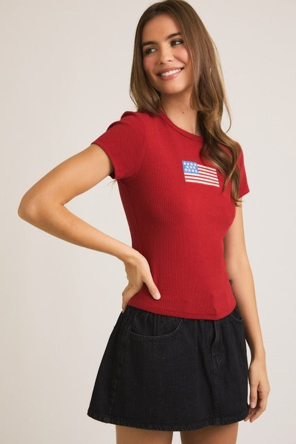 Rara Boutique embroidered American flag ribbed baby tee featuring patriotic flag design and comfortable fitted style.