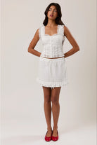 RARA Boutique sleeveless square neck blouse with eyelet lace trim, featuring a stylish and feminine design.