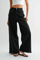 RARA Boutique studded ultra wide-leg washed jeans with distressed details and belt loops, styled with a casual top.