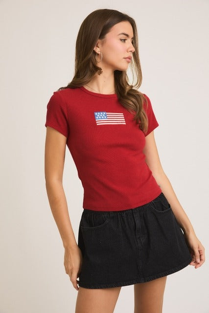 Rara Boutique embroidered American flag ribbed baby tee featuring patriotic flag design on soft cotton T-shirt for kids.