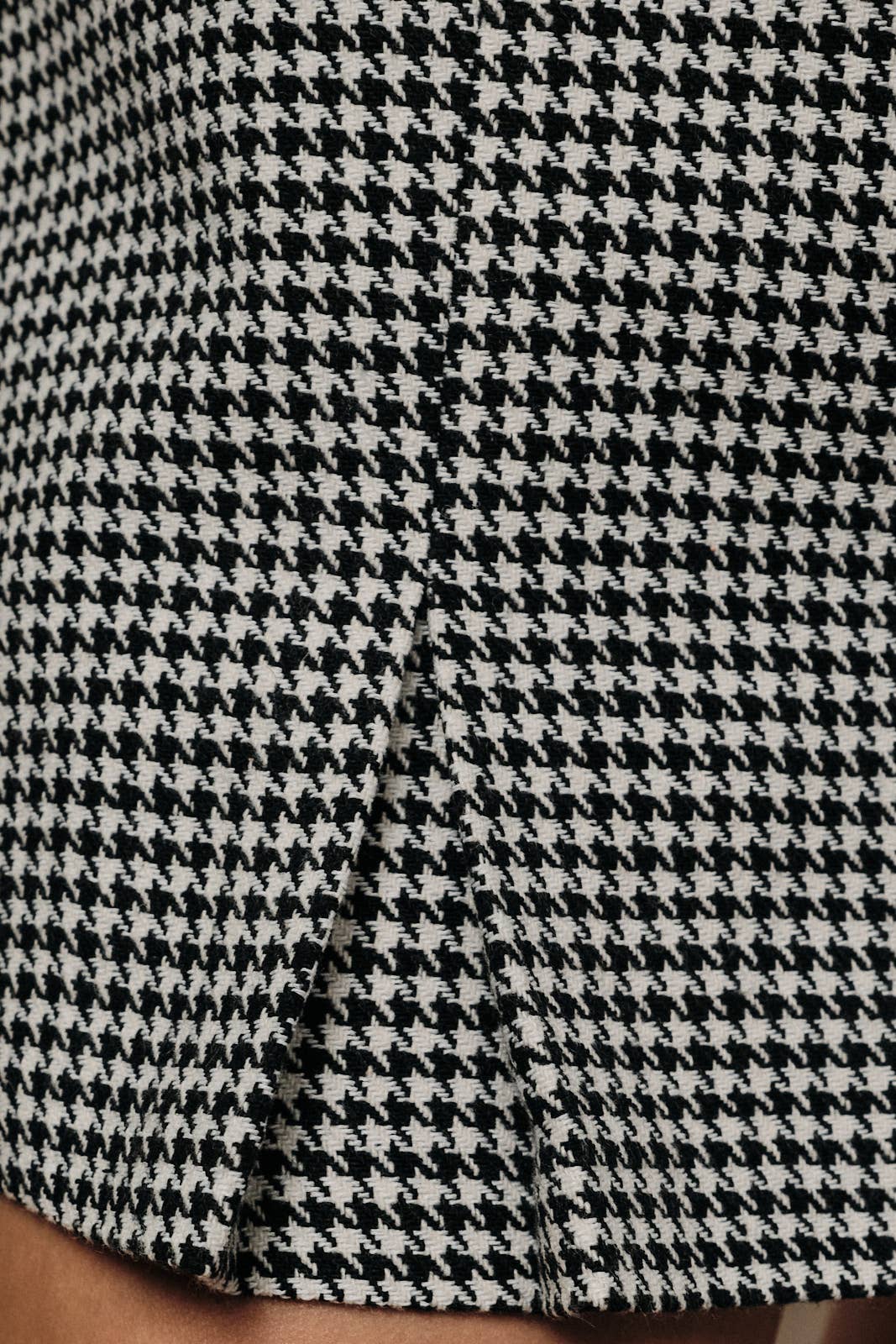 Sunday Edition by LE LIS houndstooth mini skort with front pockets, styled on a model for a trendy, casual look.