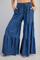 RARA Boutique mineral washed denim palazzo pants with tiered ultra-wide legs and relaxed fit, shown on a model.