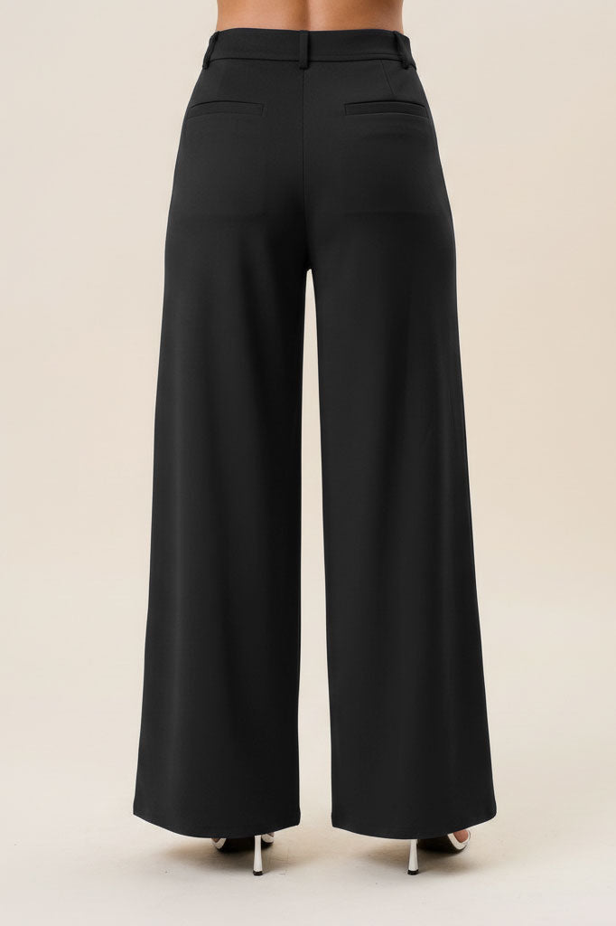 Black high waist tailored wide-leg trousers by RARA Boutique, made of smooth fabric with a fitted waistband and flowing leg design.