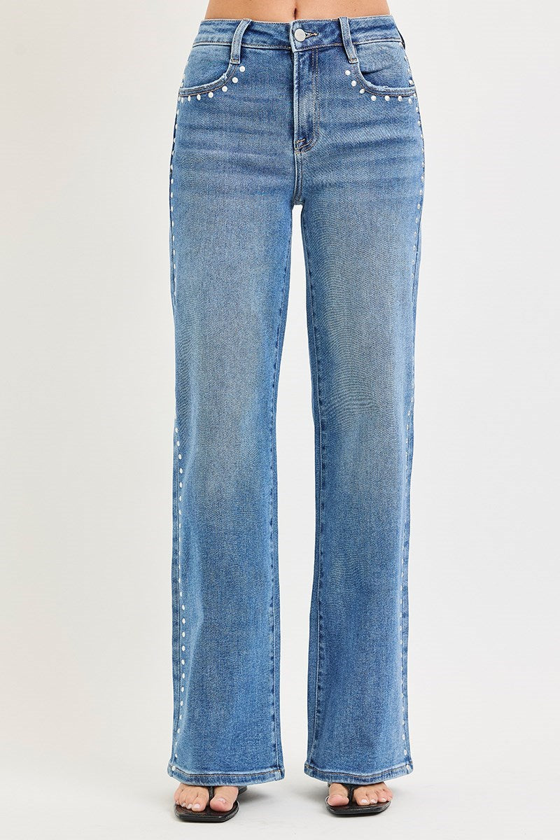 Medium wash Risen studded wide-leg high-rise jeans with belt loops and distressed details, styled with a casual look.