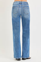 Medium wash Risen studded wide-leg high-rise jeans with belt loops and distressed details, styled with a casual fashion look.