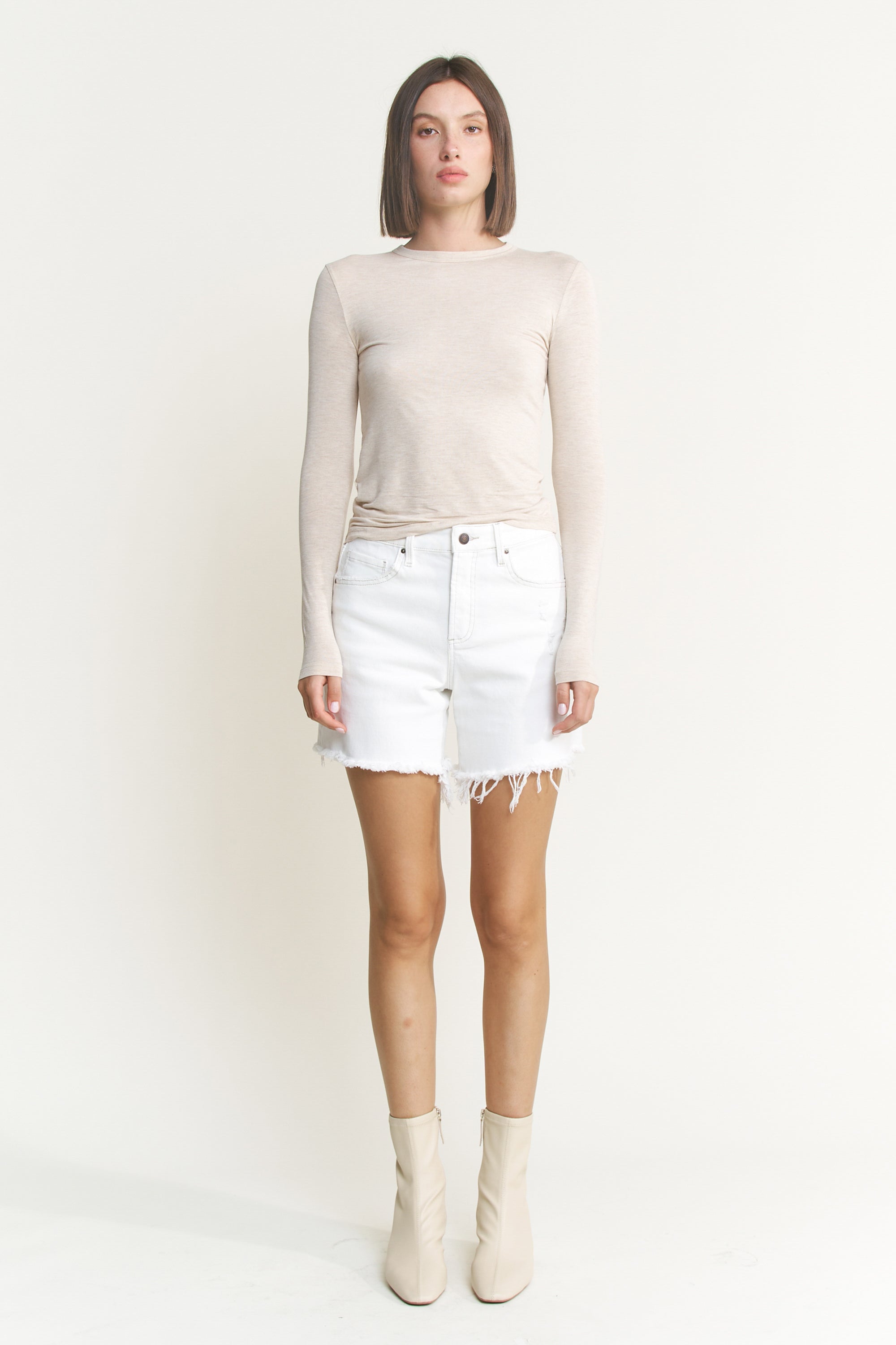 Mid-thigh length high rise raw hem denim shorts from RARA Boutique, featuring a stylish raw hem and classic blue denim.