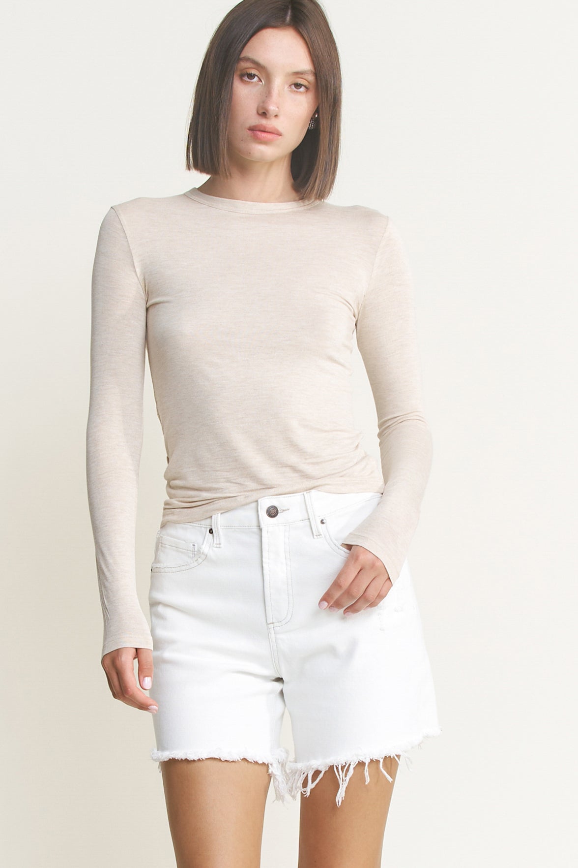 High rise raw hem denim shorts by RARA Boutique, mid-thigh length, in light wash denim with distressed raw hem detail.