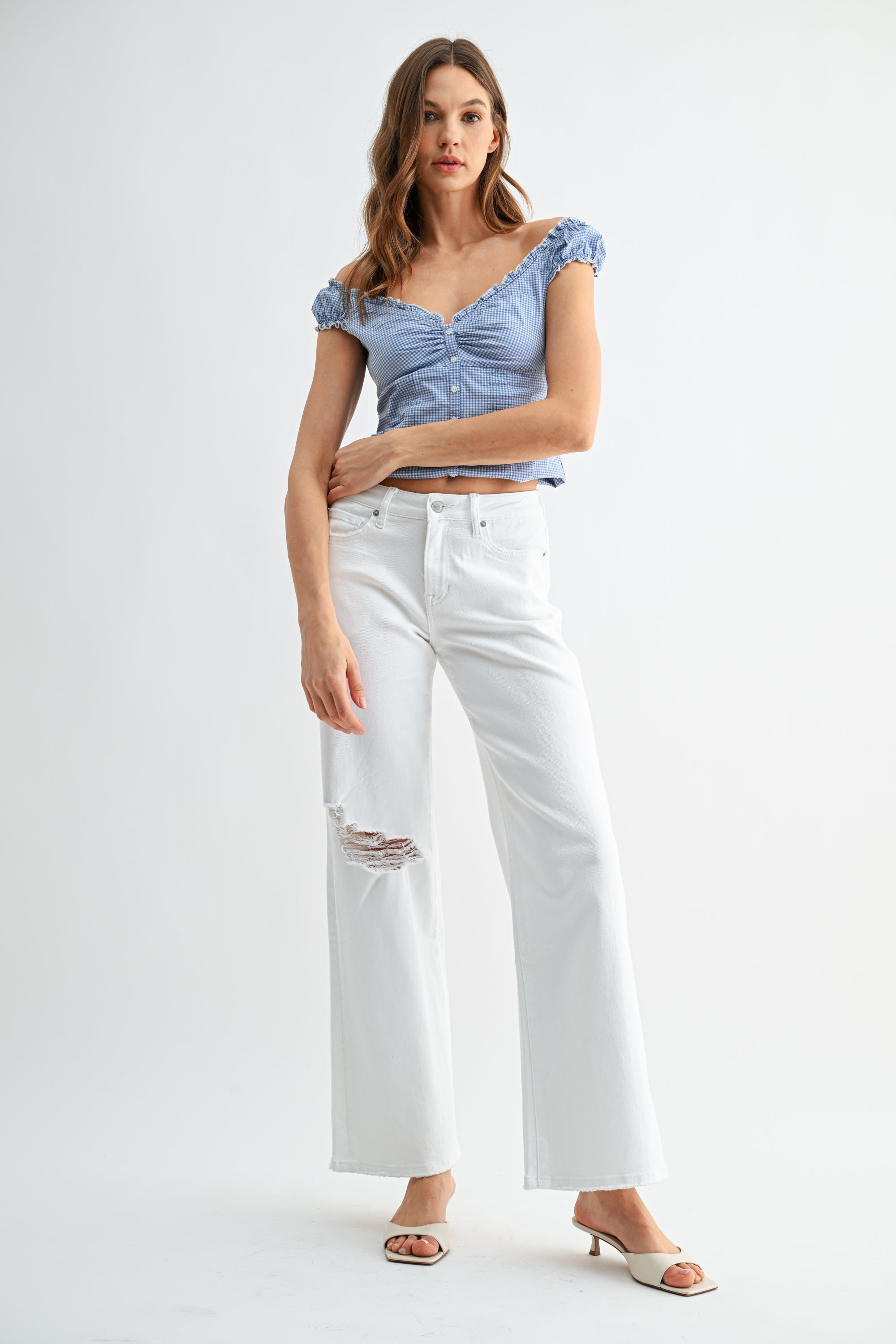 Mid-rise distressed wide-leg jeans by RARA Boutique, featuring frayed hems and a relaxed fit in classic denim.