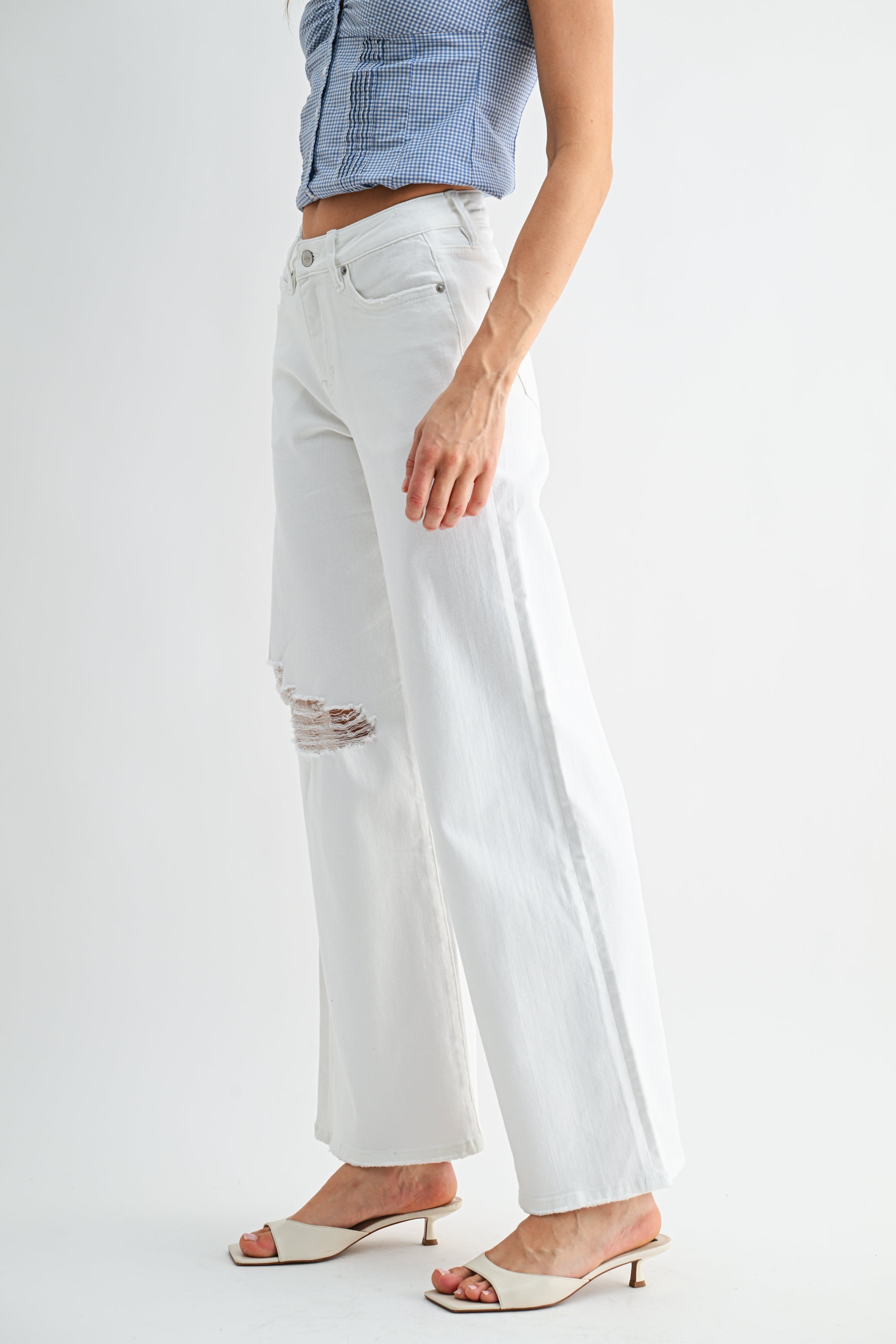 Light wash mid-rise distressed wide-leg jeans from RARA Boutique with frayed hems and relaxed fit.