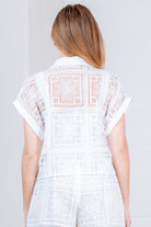 RARA Boutique floral crochet button-down collared blouse with intricate patterns and lightweight fabric, displayed on a hanger.
