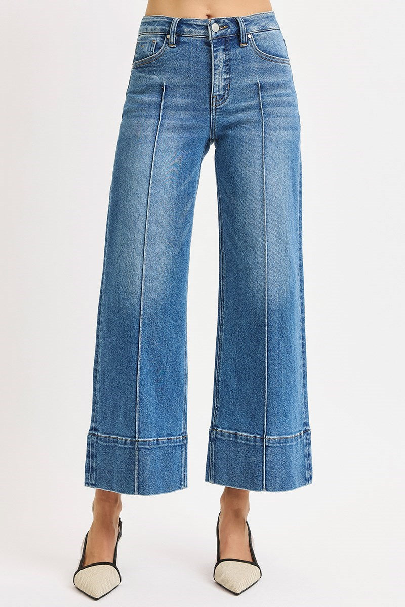 Medium wash Risen pintuck tummy control wide leg cropped jeans with wide hem, showcasing stylish fit and relaxed silhouette.
