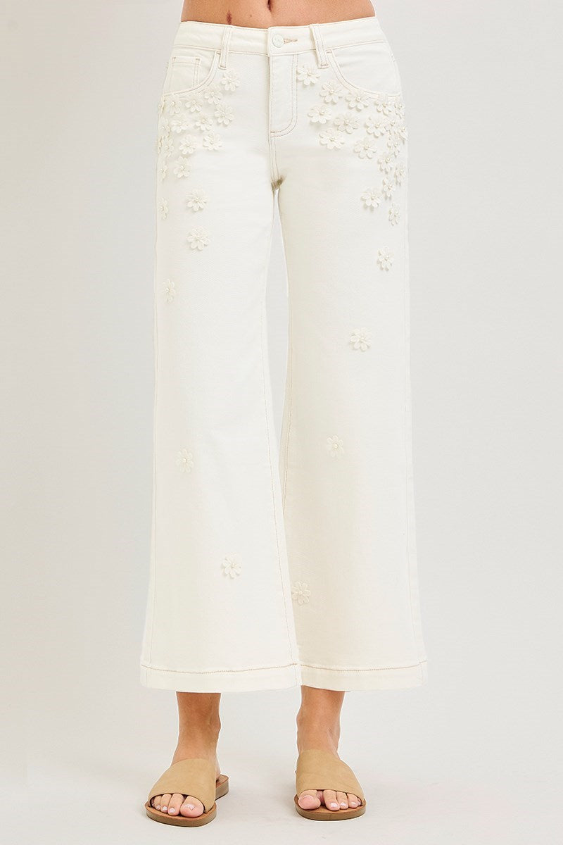 Cream wide-leg cropped jeans with 3D flower and pearl embellishments by RARA Boutique, showcasing detailed floral and pearl accents.