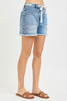 Light wash grommet waist tie cutoff denim shorts by Risen, featuring distressed edges and a casual fit.
