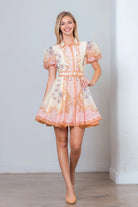Pink Baroque scrollwork floral mini dress by RARA Boutique with pearl belt, showcasing elegant design and intricate pattern.