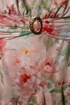 Watercolor floral ruffle halter mini dress in peach by RARA Boutique, showing the dress's flowy fabric and floral pattern.