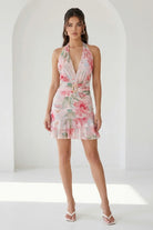 Watercolor floral ruffle halter mini dress in peach by RARA Boutique, featuring a feminine design with ruffled details and halter neckline.