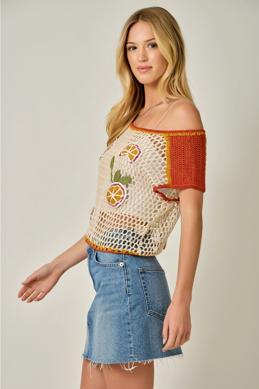 Open-knit crochet citrus fruit top from Mystree, a lightweight shirt with colorful fruit pattern, seen on a RARA Boutique model.
