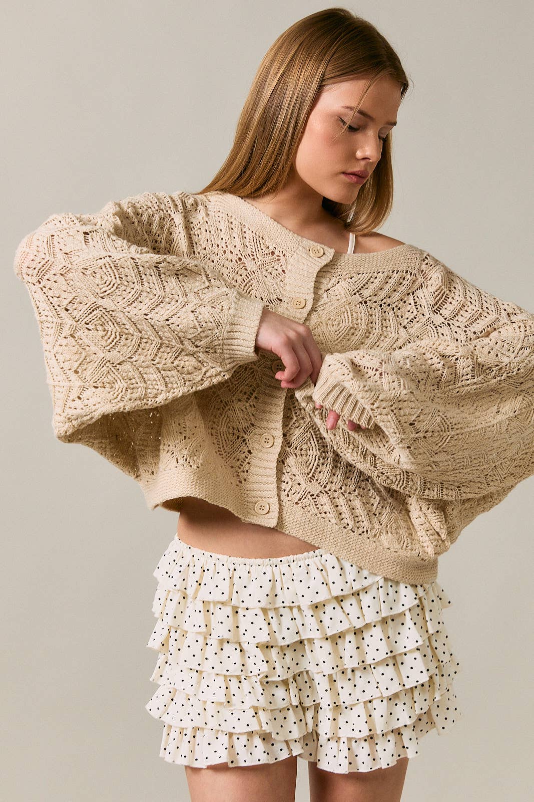 Long sleeve crochet cardigan by LE LIS, featuring detailed knit pattern and open-front design, worn casually over a top.