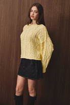 Le Lis oversized cropped cable knit sweater in soft wool with chunky cable patterns and a cozy fit.