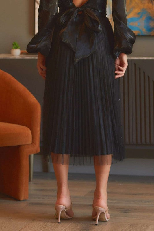 Pearl-embellished pleated mesh midi skirt by RARA Boutique with a main strip, showcasing elegant detailing and flowy fabric.
