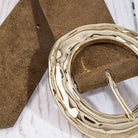 Suede hammered round buckle belt by Collections by Fame Accessories showing a close-up of the textured suede strap and round metal buckle.