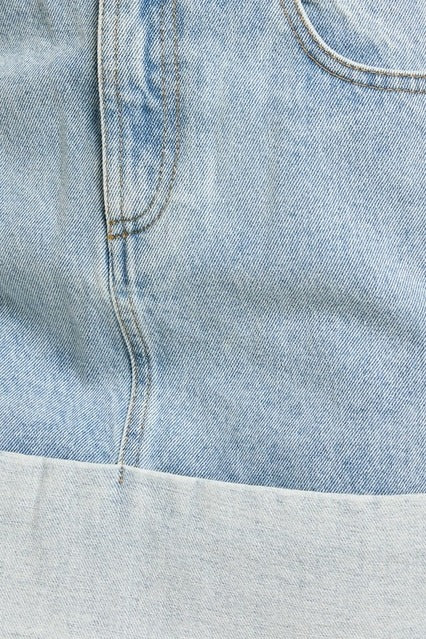 Le Lis high waisted denim mini skirt with cuffed hem, showcasing a fitted style and classic blue wash.